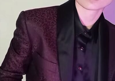 A woman in a suit with pink hair, posing in an urban setting in Chicago, IL