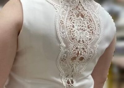 A woman in a white lace-back dress stands elegantly in Chicago, IL